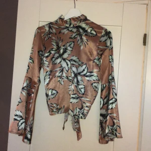 Silkesblus - Silkesblus från NA-KD. Superfin knytning i ryggen, se bild 3. Vackra utsvängda armar. Köparen står för frakt.