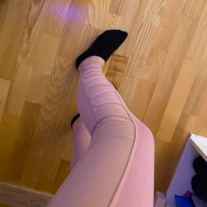 Träningstights - Säljer rosa träningstights som ej är använda. De är korsade på sidan av båda benen, annars är de helrosa. Säljer för 100kr+Frakt. Kontakta mig vid frågor eller om fler bilder önskas💗