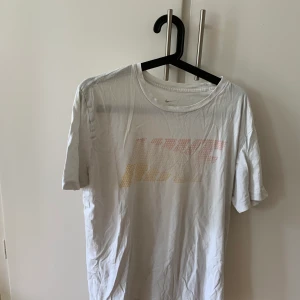Nike T-shirt - Snygg vit t-short i märket Nike som är tyckt på framsidan ljusa snygga färger.