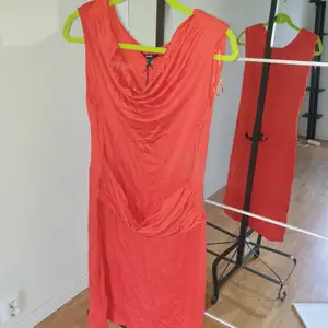 Orange röd klänning m axelvaddar i trikå