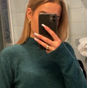 Grön stickad tröja - Säljer en så fin stickad träja med lite polo i halsen. Så fin mörk grön förg. (Färgen är lite mer mörkare gröna i verkigheten) storlek XS