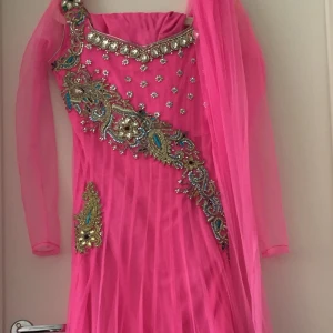 Rosa afghansk klänning  - Rosa afghansk klänning, använt ett par gånger, jättefin, har små diamanter på sig, säljer med frakt har en rosa sjal o byxor  