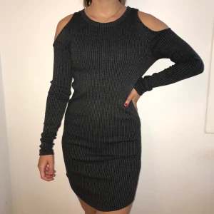 OANVÄND KLÄNNING FRÅN GINA TRICOT - En helt oanvänd ribbad klänning från Gina tricot med utskärningar vid axlarna. Köparen betalar frakt!