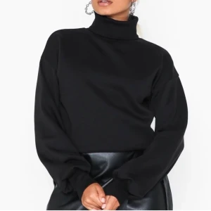 Tröja från Nelly - Svart tröja från NLY Trend med ”polokrage”, snygg detalj vid slutet av armarna (andra bilden). Tröjan är lite kortare i modellen och ser ut som att den är avklippt (syns på första bilden), använd 2 gånger så i mycket bra skick. Frakt ingår i priset🤜🏼🤛🏼