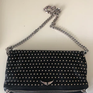 Zadig Voltaire väska  - En jättefin väska från Zadig Voltaire med massa små nitar på. Man får med ett till längre band. Fri frakt. Den är i bra skick. Nypris : 4500