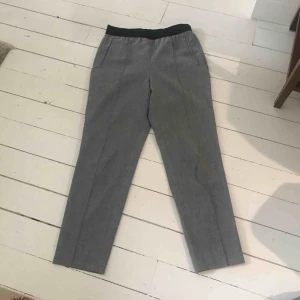  - Kostymbyxor med resår i midjan. Låg midja. 