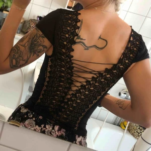  - Otroligt vacker topp med spets och snörning i ryggen. Skönt material som sitter snyggt på kroppen. Sparsamt använd. 