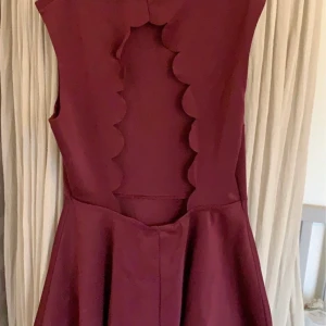 Vinröd klänning med öppen rygg - Storlek M - OK ATT KOMMA MED BUD. Hög framtill och öppen i ryggen (baksidan på bild). Inga hål eller fläckar. Använd enstaka gånger. Tvättad parfymfritt.  