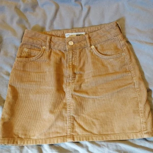 Topshop Petite, manchester kjol, storlek 34 - Kjolen är mindre då den är i Petite, plaggets längd är ca 38cm. Köpt på Zalando. Säljer då den är för liten, använd endast ett fåtal gånger. Passar en som vanligtvis har xs eller 34. Köpare står för frakt.