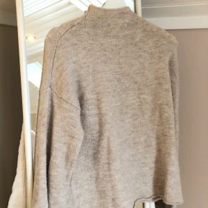 beige tröja med utsvängda ärmar  - beige tröja med halvhög krage och utsvängda ärmar från BikBok i storlek S. köparen står för frakten!!