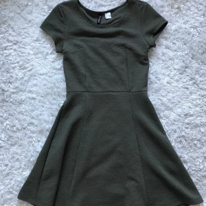 Olivgrön klänning i stretch  - Klänning med perfekt stretch. Sätter sig som en smäck. Från HM, storlek 34. Kan mötas upp i Stockholm eller frakta. 