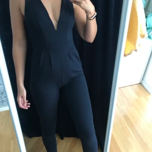 Byxdress från Boohoo - Mörkblå byxdress från Boohoo i storlek Medium. Tecken på användning finns då en söm har gått upp strax under dragkedjan, se bild 3.