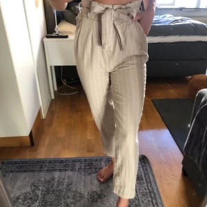 Byxor i linnematerial - Beige med vita små ränder från Gina tricot. Använda en gång. 