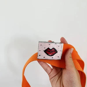 Oranget skärp med hemmagjort print! - Assnyggt skärp med hemmagjort tryck. Passar alla storlekar eftersom man spänner åt skärpet så mycket man vill. I gott skick💖