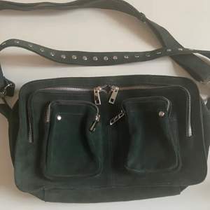 Säljer jättefin mörkgrön väska i mocka från danska märket Nunoo i modellen Alimakka! Köpt för 1600 kr på Nelly.com. Väskan är rymlig och nästan helt oanvänd, endast använd 2 gånger!💚💚 hör av er vid frågor