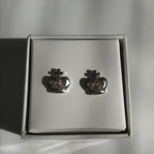 Örhängen - Silvriga små örhängen med kronor och små rosa stenar. 10kr + frakt 11kr (tar bara swish).