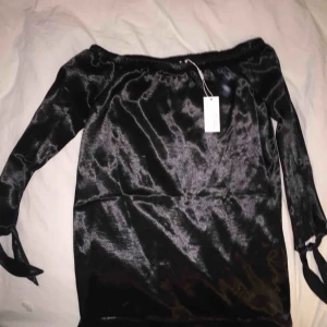  - Off the shoulder glansig svart korr klänning från NLY trend. Oanvänd