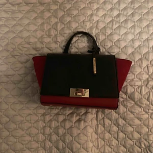  - liten Svart och röd väska med guld detaljer. Mocka imitation på sidorna. Inköpt i Paris från lafayette. Axelrem medföljer. 