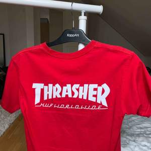 Thrasher & HUF röd t-shirt. knappt använd. thrasher trycket sitter på ryggen. den har inte breda axlar den hänger bara dåligt på galgen. pris kan diskuteras