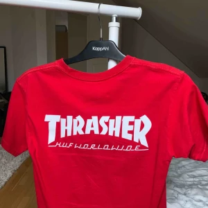  - Thrasher & HUF röd t-shirt. knappt använd. thrasher trycket sitter på ryggen. den har inte breda axlar den hänger bara dåligt på galgen. pris kan diskuteras