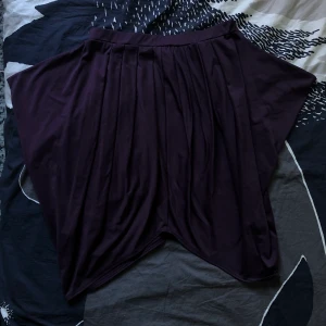 Lila kjol från monki - Asnajs, flowy kjol från monki. Fint skick och väldigt skön. Pga stretch passar den small-medium skulle jag säga. Passar perfekt under en lång tröja så bara nederkanten sticker ut eller som den är!