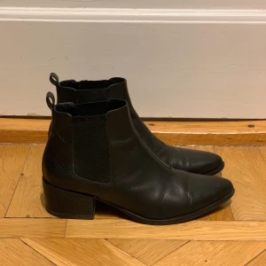 Vagabond stövletter 39 - Svarta stövletter / Chelsea boots med spetsig tå. Sparsamt använda, kan tyvärr inte längre ha kvar dem efter att ha opererat ena foten. Snygga till allt. Bra skick och har precis smort in dem med läderfett.  Märke: Vagabond Storlek: 39  Har Swish. Hämtas i Skanstull eller skickas mot porto. Rökfritt & Djurfritt hem.
