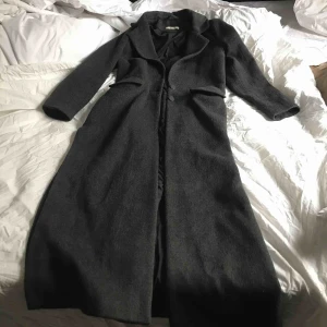  - Blandad ull kappa i mörk-grå. Perfekt skick, knappt använd. 
