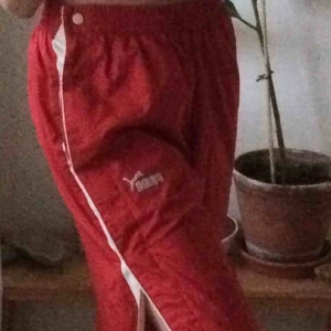 - Jätte snygga röda puma trackpants med knappar längs sidorna! Köpte de på Humana men har själv aldrig använt de, därav säljer jag de. De är i bra skick och skulle säga att de passar S - M i och med att de har resårband i midjan!! 