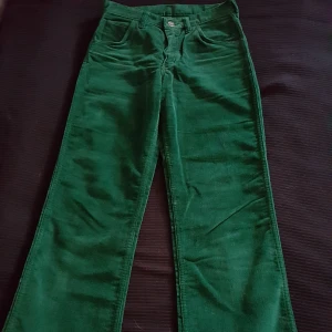  - Mörkgröna, vida Wrangler manchesterbyxor från 70-talet. Storlek 28, dock små i storleken. Svåra att få till bra på bild. Finns i Örebro men kan skickas om köparen står för fraktkostnaden.