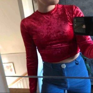  - Röd croppad långärmad tröja i krossad sammet. Väldigt snygg och skön. Säljer pga aldrig använd. Köparen står för frakt.