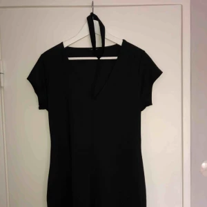  - Svart kortklänning med en inbyggd choker. 