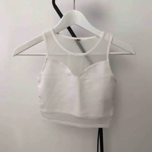  - En snygg vit topp med genomskinliga delar. (Frakt tillkommer om den ska skickas)