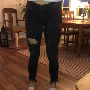  - Jeans med slitningar på knäna och blommor på vänsterbenet, från Zara I ganska bra skick