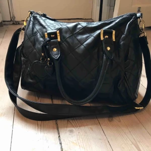 Svart handväska  - Svart medelstor väska med axelrem. Hämtas upp i Bromma eller frakt. 