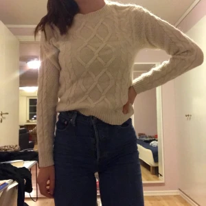 Vit stickad tröja  - Vit stickad tröja med guldiga knappar på vänster axel. Väldigt fint skick, använd någon enstaka gång.