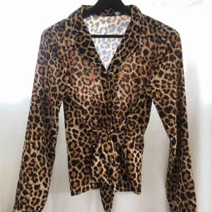  - Leopardblus med ett band runt om som snyggt formar midjan. Helt oanvänd och i fint sick. 