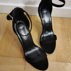 Klackskor med spänne 36 - Klackskor från Boohoo köpta i somras men aldrig använda. I mockaimmitation och spänne kring ankeln. Klacken är ca 10 cm. Kan mötas upp i centrala gbg. Hör av er om ni har frågor! [FRAKT INKLUDERAT I PRISET]