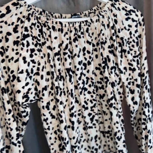  - Beige blus med svarta detaljer. Den är i ett jättefint skick då jag bara använda den en gång. Fungerar jättebra för dig med storlek M också! :) off shoulder