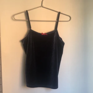 croppat linne! - köpte den här second hand men knappt använd av mig pga för liten! den är ett jättegulligt sammetslinne i mörkblått med den rosa rosetten. lappen är tyvärr bortklippt men skulle säga nånstans xs-liten m. jag brukar ha L