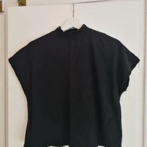 T-shirt m. Polokrage - Svart T-shirt m. Polograge. Knappt använd. Frakt tillkommer