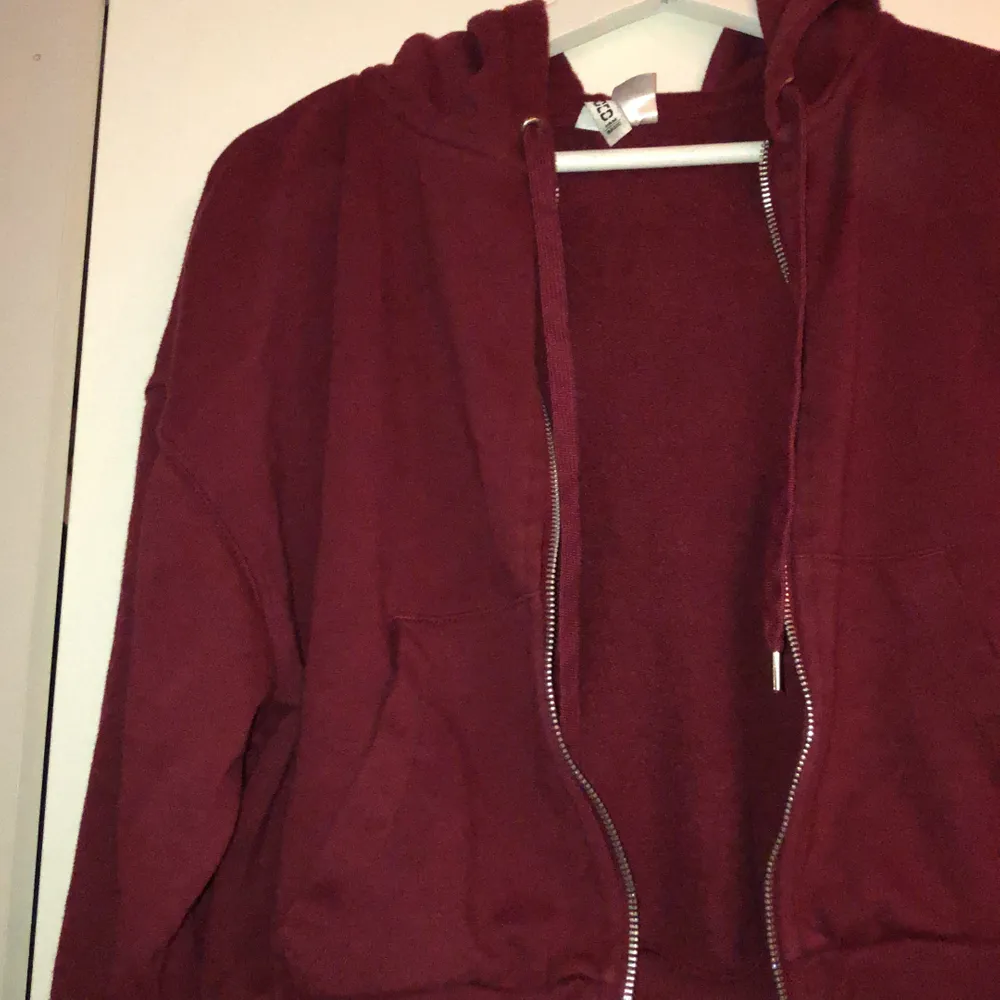 Vinröd hoodie med luva och zipper. Den är croppad. Passar s-m . Hoodies.