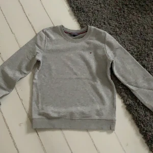 Tommy hilfiger sweatshirt strl XS - Grå Tommy hilfiger sweatshirt med märket längst upp till vänster. Strl XS, passar folk mellan 160-170cm. Använts väl men är fortfarande i bra skick. Hör gärna av dig vid intresse, pris kan diskuteras!