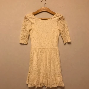  - Jättesöt cremefärgad klänning i storlek XS. Använd en gång på en konfirmation! Inköpt på SOLO i Stockholm för 500 kr. Klänningen är i spets med mjukt foder och slutar strax ovanför knäna. Dragkedja i ryggen. Ryggen är lite urringad. Frakt tillkommer.