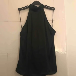 - Topp i silkmaterial, svart med öppenrygg och knyt i nacken!