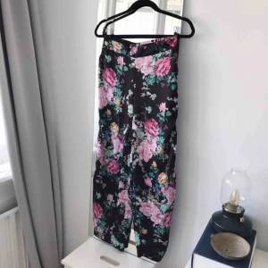  - Högmidjade blommiga byxor från Gina Tricot i storlek 36. Lite sidenliknande material. Frakt ingår!