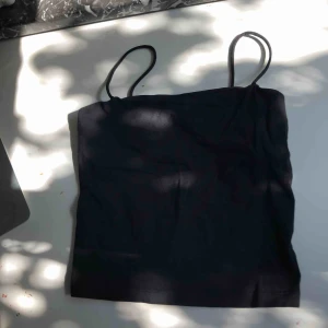  - Svart linne med spaghetti straps. Från gina tricot.