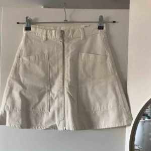 - Jättefin kjol från monki, knappt använd! Sitter som en smäck med dragkedja fram och stora fickor, A-linjeformad i vit/beige färg! 