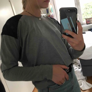  - Grå långärmad tröja med svarta små hål, man ser huden lite igenom men det är inte jätte mycket.  Den är från peak performance därav bra material som håller länge. Köpte den för ungefär 1 år sedan och använts 1 gång.