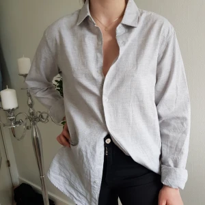  - Ljust ljust blågrå skjorta i herrmodell, dvs lite större än en M för kvinnor.