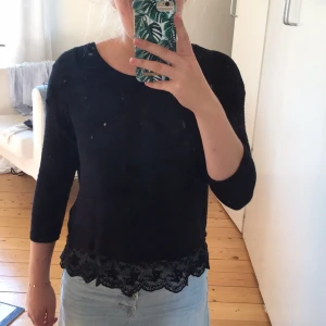  - Svart stickad tröja med spets nedtill. 